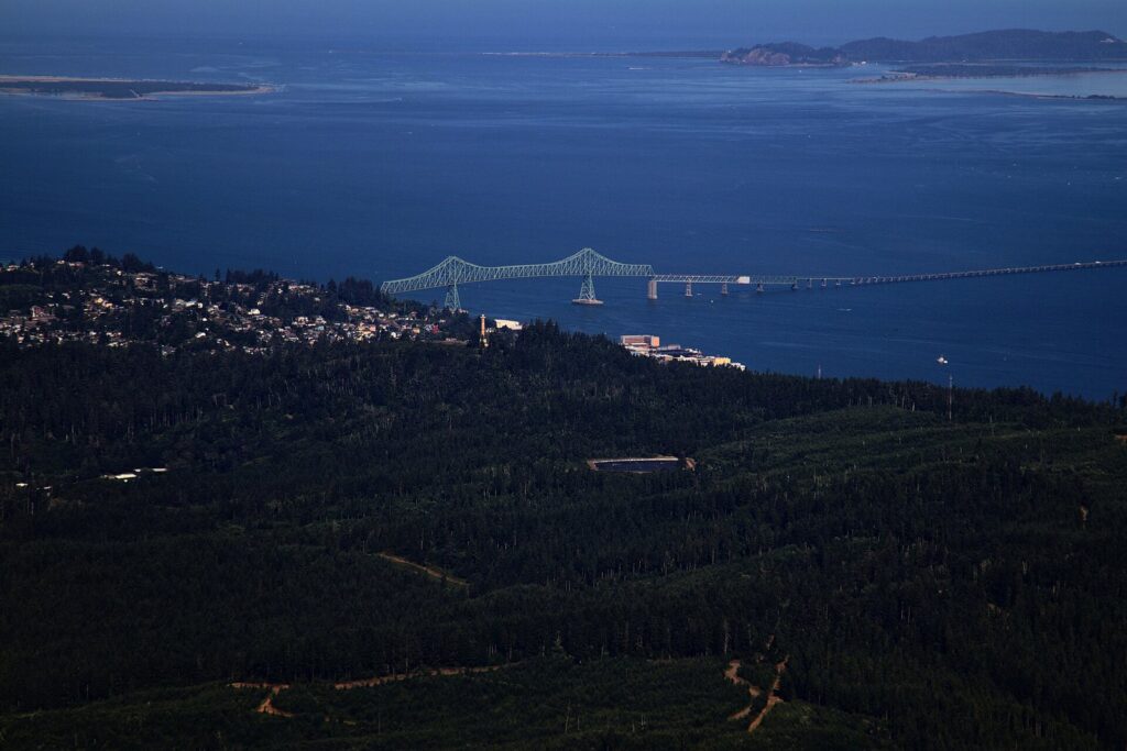 The long Astoria-Megler Bridge crossing the wide mouth of the Columbia River, seen from high above Astoria's hillside neighborhoods
