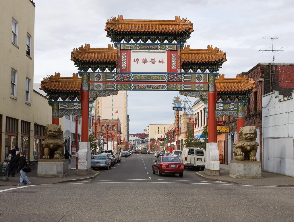 The ornate Chinatown Gate with tiled roofs and bronze lions standing over NW 4th Avenue