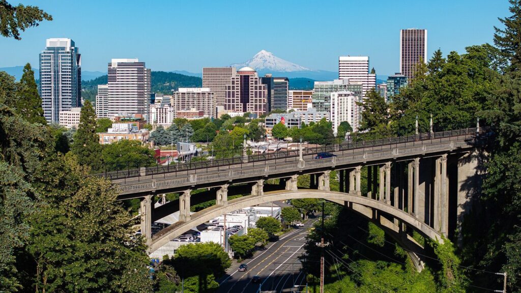 Downtown Portland towers behind the arched Vista Bridge, with snow-capped Mount Hood on the horizon