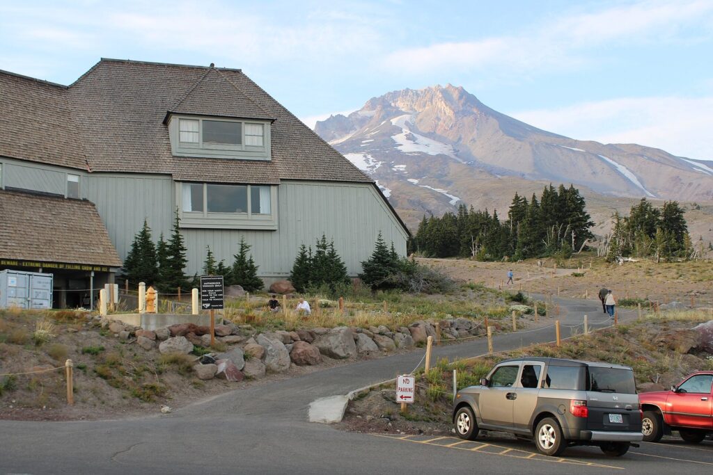 The steep shingled roofs of Timberline Lodge with the rocky, snow-streaked summit of Mount Hood rising behind