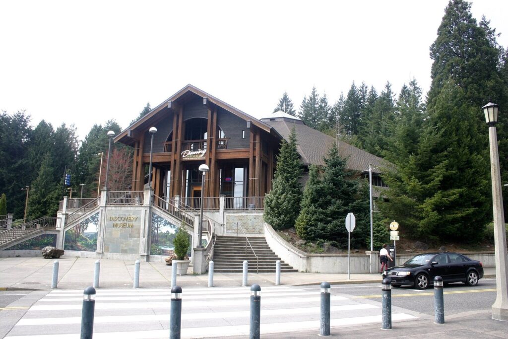 The timber-framed entrance hall of the World Forestry Center's Discovery Museum, set among tall conifers